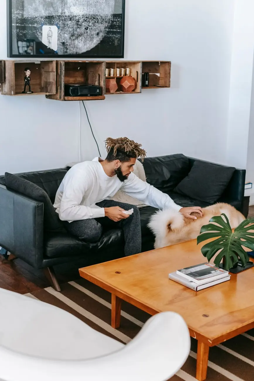 Man relaxing on a sofa with his dog